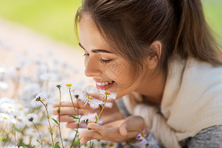 园艺人们的快乐的轻女人闻洋甘菊花夏季花园靠近闻洋甘菊花的女人图片