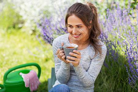 园艺人们的轻的女人夏季花园喝茶轻的女人夏天的花园喝茶图片