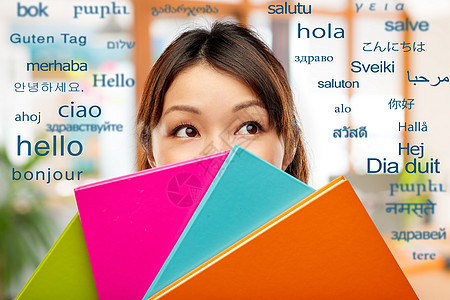 教育学校知识亚洲妇女学生女孩躲笔记本后,用同的外语问候语躲笔记本后的亚洲女人学生图片
