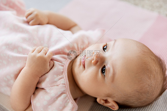 婴儿期人们的可爱的小女孩躺针的粉红色毯子上可爱的女婴躺针毛毯上图片