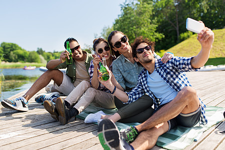 休闲,野餐技术朋友与饮料采取自拍智能手机湖墩夏季公园饮料的朋友用智能手机自拍图片