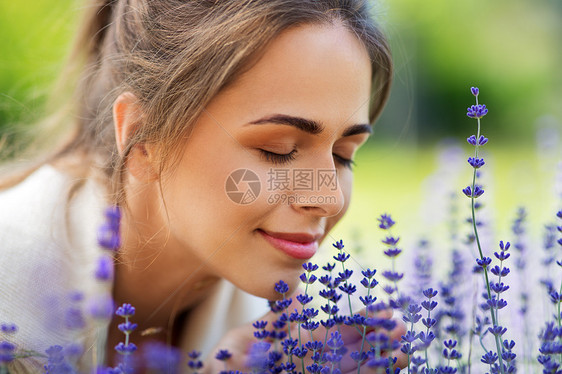 园艺人们的夏季花园里,快乐的轻女人闻着薰衣草的花靠近闻着薰衣草花的女人图片