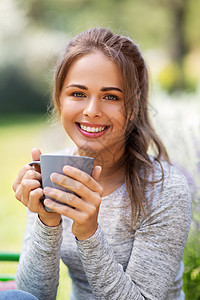 园艺人们的轻妇女夏季花园喝茶咖啡的肖像夏天花园里喝茶咖啡的女人图片