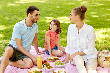 家庭,休闲人的快乐的母亲,父亲女儿夏季公园野餐快乐的家庭夏天的公园野餐图片