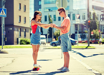 暑假,极限运动人们的快乐的十几岁的夫妇骑着短的现代巡洋舰滑板城市街道轻夫妇城市街道上骑滑板图片