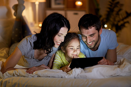 人们家庭的快乐的母亲,父亲小女儿家里晚上床上用平板电脑家庭与平板电脑床上晚上家图片