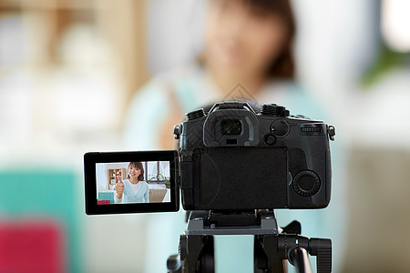 博客,技术,视频博客购物相机记录视频博客快乐微笑的亚洲妇女博客竖大拇指家里的手势女博主制作关于购物的视频图片