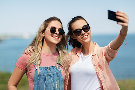休闲友谊快乐微笑的十几岁女孩最好的朋友太阳镜拥抱自拍智能手机海边夏天十几岁的女孩朋友夏天自拍图片