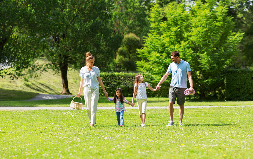 家庭休闲人的快乐的母亲带着野餐篮,父亲两个女儿夏季公园散步家人带着野餐篮夏天的公园散步图片