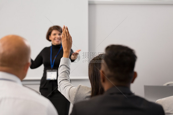 商业,教育人的微笑的女商人教师回答问题演讲讲座上回答问题出席商务会议讲座的群人图片