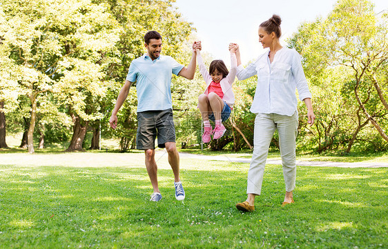 家庭休闲人的快乐的母亲父亲小女儿夏季公园散步,玩得开心快乐的家人夏天的公园散步图片