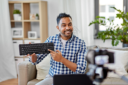 博客,视频博客人的印度男博客与相机记录视频审查电脑键盘家里男视频博客与键盘视频博客背景图片