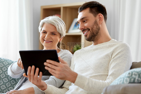 家庭,世代技术快乐微笑的高级母亲成儿子与平板电脑家迈的母亲成的儿子家用平板电脑图片
