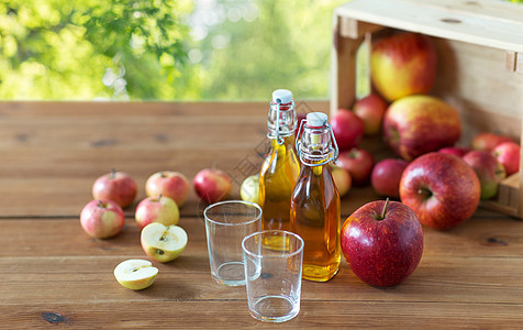 水果,食物收获的两杯瓶苹果汁苹果酒木制桌子上绿色自然背景木制桌子上的眼镜苹果汁图片