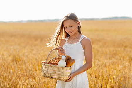 自然,健康的饮食机的微笑的轻女孩着柳条篮子与包牛奶谷物场夏天谷物地里篮子里包牛奶的女孩图片