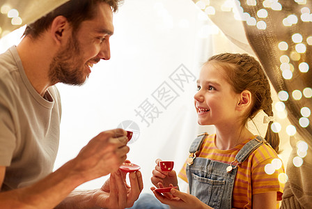 家庭,潮格人的快乐的父亲小女儿孩子们的帐篷里晚上家玩茶话会家庭孩子们的帐篷里玩茶话会图片