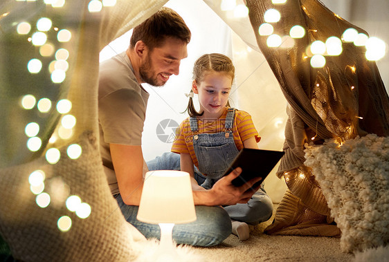 家庭,技术快乐的父亲小女儿孩子们的帐篷里晚上家用平板电脑电脑家里平板电脑孩子们的帐篷里图片