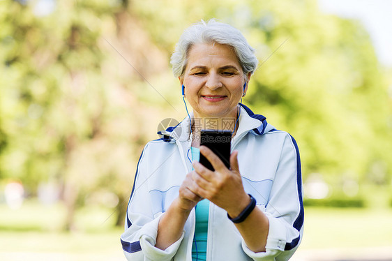 健身,运动健康的生活方式老妇女与耳机听音乐智能手机夏季公园带耳机智能手机的感高级女人图片