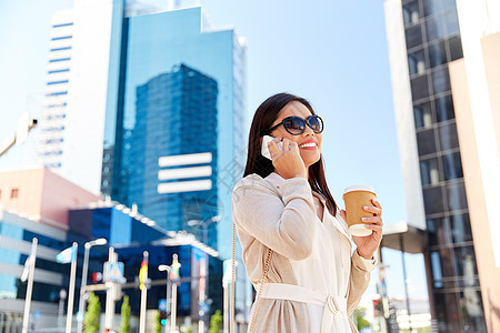 沟通,生活方式技术快乐微笑的轻亚洲妇女戴着太阳镜,带着外卖咖啡杯,城市街道上打电话给智能手机微笑的亚洲女人城市图片