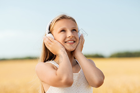 技术人的快乐女孩的肖像耳机谷物领域听音乐夏天夏天谷物地里戴耳机的快乐女孩图片