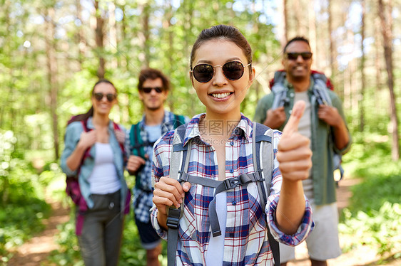 旅行,旅游,徒步旅行人的群朋友背包亚洲妇女森林里竖大拇指的手势背包的朋友森林里竖大拇指图片