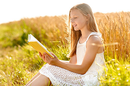 乡村,文学休闲微笑的轻女孩穿着白色连衣裙阅读书谷谷田夏天微笑的轻女孩读谷物领域的书图片