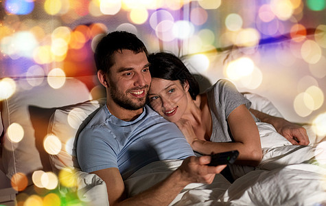 人,家庭休闲的快乐的夫妇晚上家床上看电视快乐的夫妇晚上家床上看电视图片