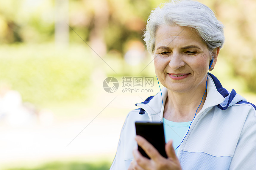 健身,运动健康的生活方式老妇女与耳机听音乐智能手机夏季公园带耳机智能手机的感高级女人图片