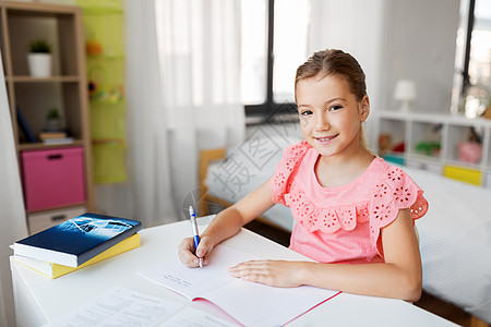 孩子,教育学理念学生女孩带着书家里写笔记本学生女孩带着书家里写笔记本背景图片