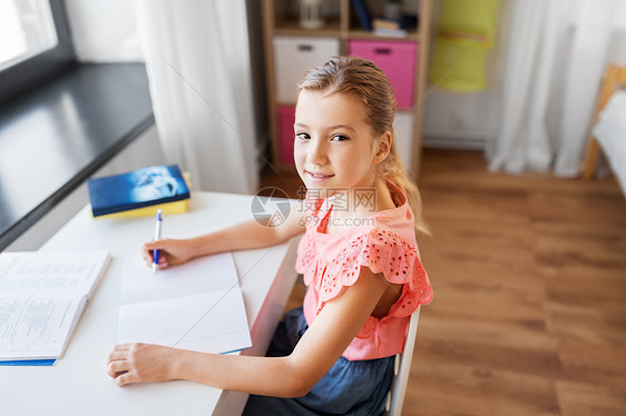 孩子,教育学理念学生女孩带着书家里写笔记本学生女孩带着书家里写笔记本图片