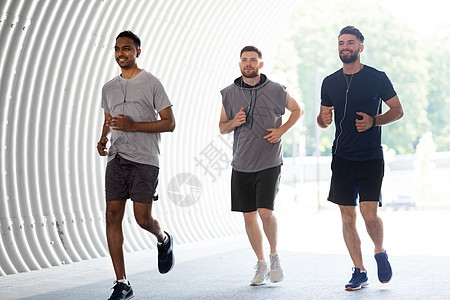 健身,运动健康的生活方式微笑的轻人男朋友与耳机运行户外男朋友带着耳机户外跑步图片