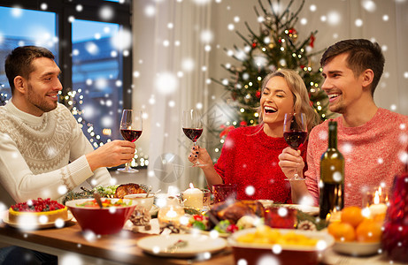 节日庆祝快乐的朋友家里吃诞晚餐,雪地上喝红酒快乐的朋友诞节聚会上喝红酒图片