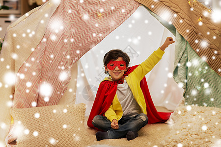 诞节童的快乐的小男孩戴着超级英雄具斗篷孩子们的帐篷帐篷家里的雪上快乐的男孩超级英雄的东西孩子们的帐图片