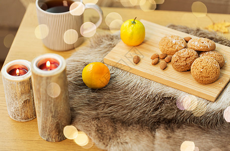 潮湿舒适的家庭燕麦片饼干,柠檬茶蜡烛木制桌子客厅饼干,柠檬茶蜡烛家里的桌子上图片