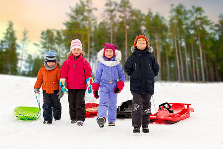 童,雪橇季节的群快乐的小孩子冬天的森林背景下玩雪橇快乐的小孩子冬天带着雪橇图片