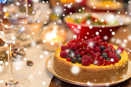 诞晚餐饮食浆果蛋糕其他食物家里的雪上把蛋糕其他食物放诞桌上背景图片