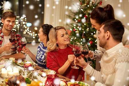节日庆祝快乐的朋友家里吃诞晚餐,喝红酒,雪地上碰杯朋友们庆祝诞节喝酒图片