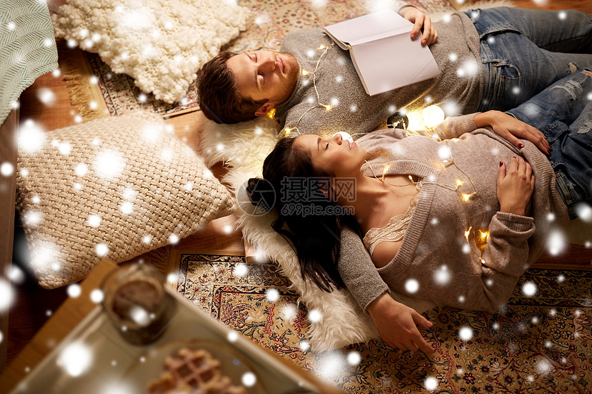 诞节,潮格人们的幸福的夫妇,书花环躺地板上,躺家里,睡雪地上幸福的夫妇花环躺家里的地板上图片