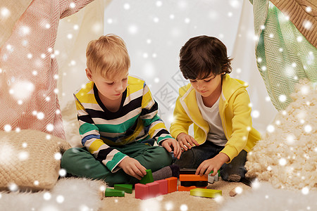 童,诞节友谊的快乐的男孩玩玩具块孩子帐篷帐篷家里的雪男孩家孩子们的帐篷里玩玩具块图片