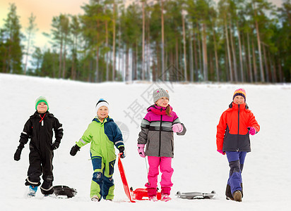 快乐的孩子们雪山上玩雪橇图片