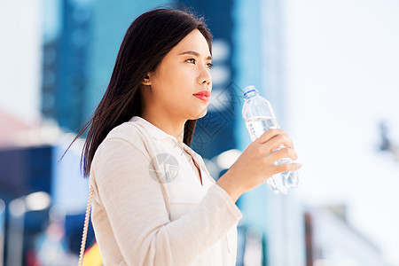 女人街上准备喝矿泉水图片