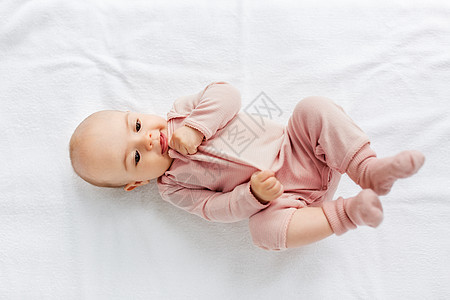 婴儿期人们的可爱的小女孩躺白色的毯子上可爱的女婴躺白色的毯子上图片