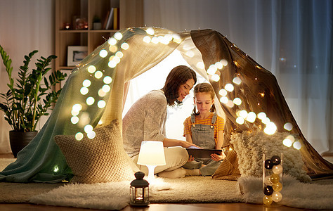 家庭,技术快乐的母亲小女儿孩子们的帐篷里晚上家用平板电脑电脑家里平板电脑孩子们的帐篷里图片