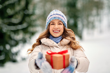 诞节,假日休闲快乐的轻妇女与礼品盒户外冬季快乐的轻女人冬天送诞礼物图片