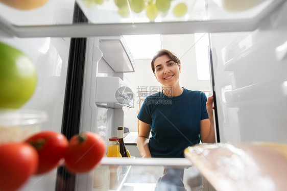 健康的饮食,食物饮食快乐的女人打开冰箱家里厨房快乐的女人家里的厨房打开冰箱图片