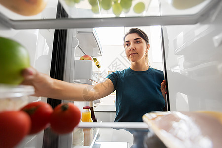 健康的饮食,食物饮食女人冰箱里苹果家厨房家里冰箱里食物的女人图片