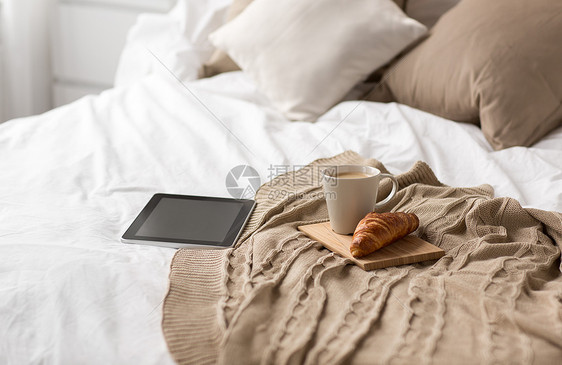 舒适,内部平板电脑,杯咖啡牛角包床上舒适的家平板电脑,咖啡杯牛角包家里的床上图片