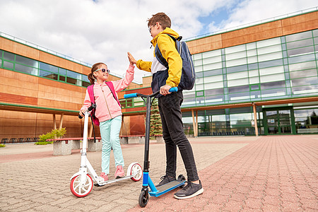 教育,童人的快乐的学校孩子与背包滑板车户外活动带背包滑板车的快乐学校孩子图片