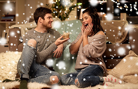 诞节,假日人们的幸福的夫妇家里的礼品盒雪上家里礼品盒的幸福夫妇图片