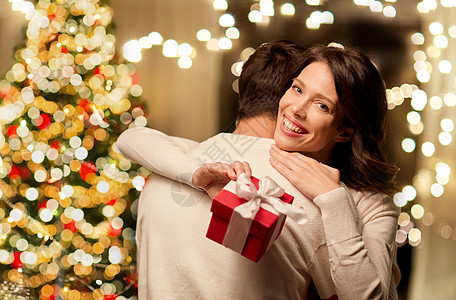 寒假人们的幸福的夫妇与诞礼物拥抱家里幸福的夫妇家里拥抱诞礼物图片